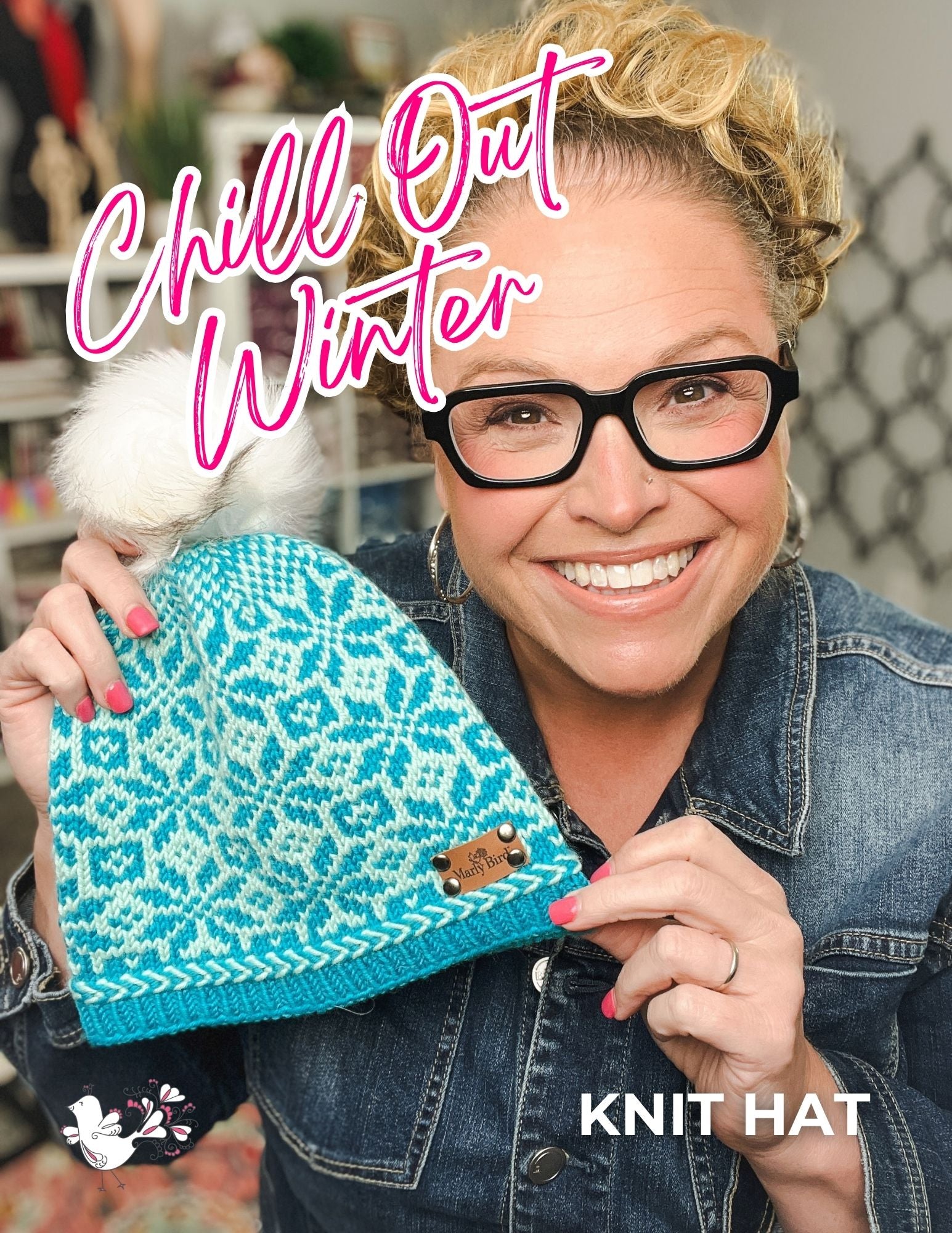 A smiling person in glasses and a denim jacket holds up the Chill Out Winter Fair Isle Hat – PDF, featuring a blue patterned Fair Isle design and a white pom-pom. The text reads “Chill Out Winter” and “Knit Hat.” Cozy decor in the background highlights the hat’s beautiful colorwork knitting pattern.