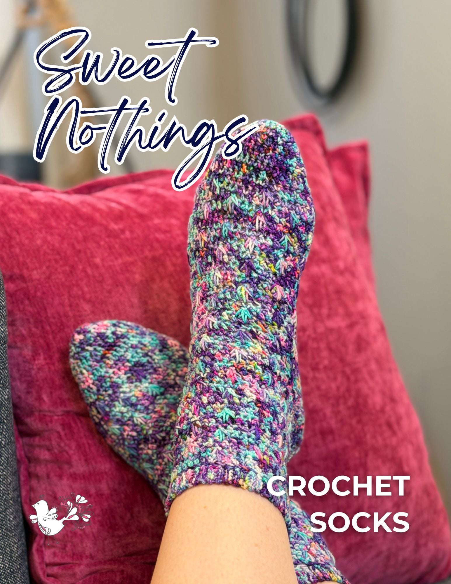 A person wearing vibrant handmade socks rests their feet on a pink pillow. The text “Sweet Nothings Crochet Socks Pattern” appears on the image, showcasing the cozy appeal of this unique crochet sock design.