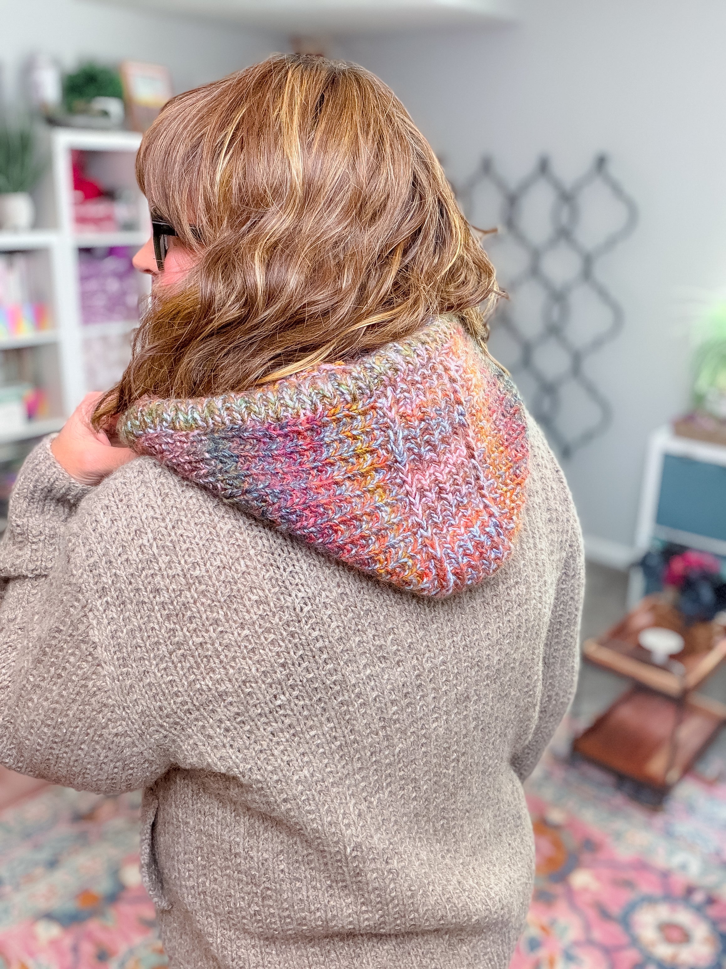 A person wearing a textured beige sweater with a Cozy Sideline Knit Balaclava - PDF draped over their shoulders.