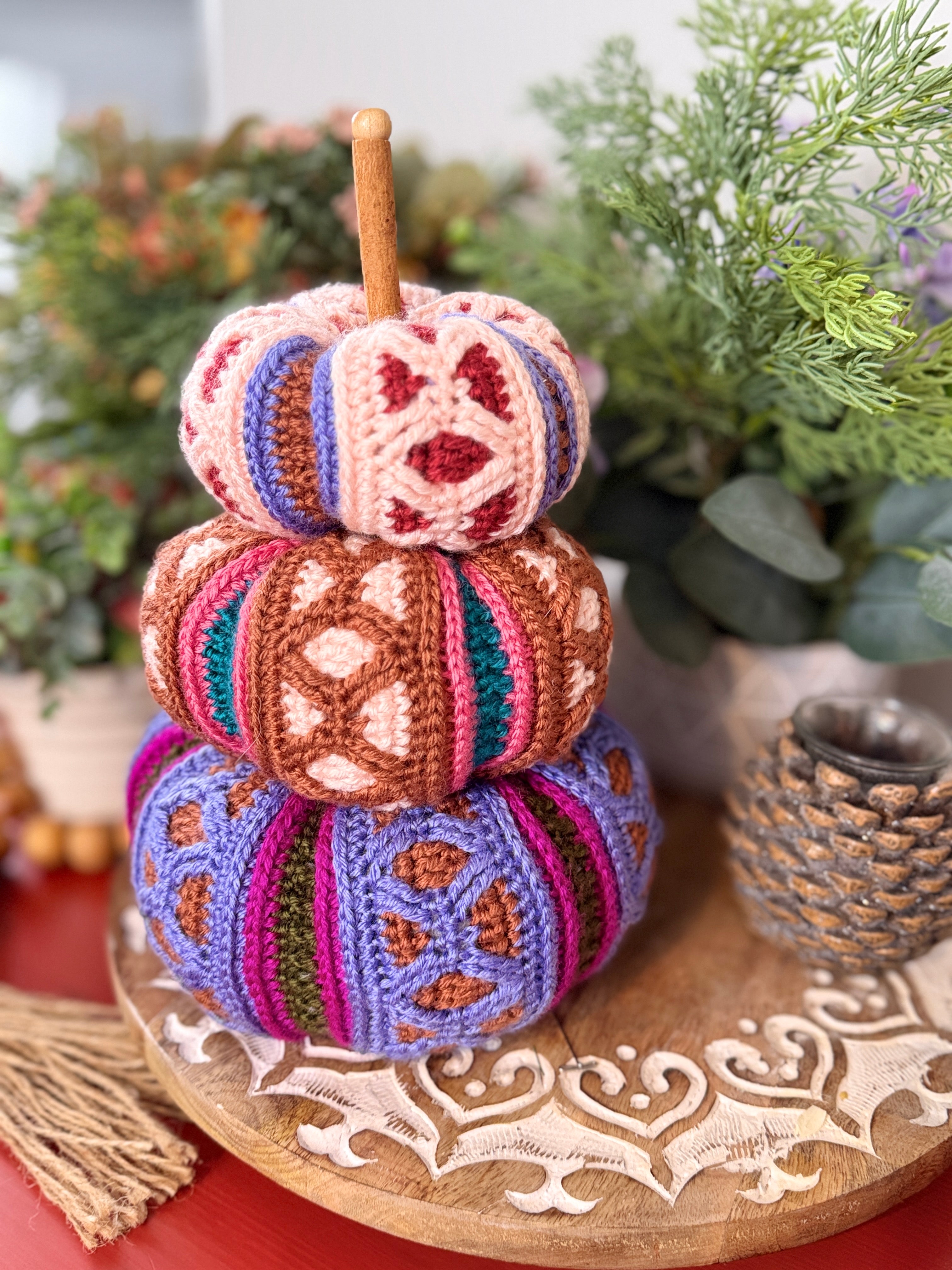 Stacked trio of mosaic crochet pumpkins in pink, brown, and purple colorways