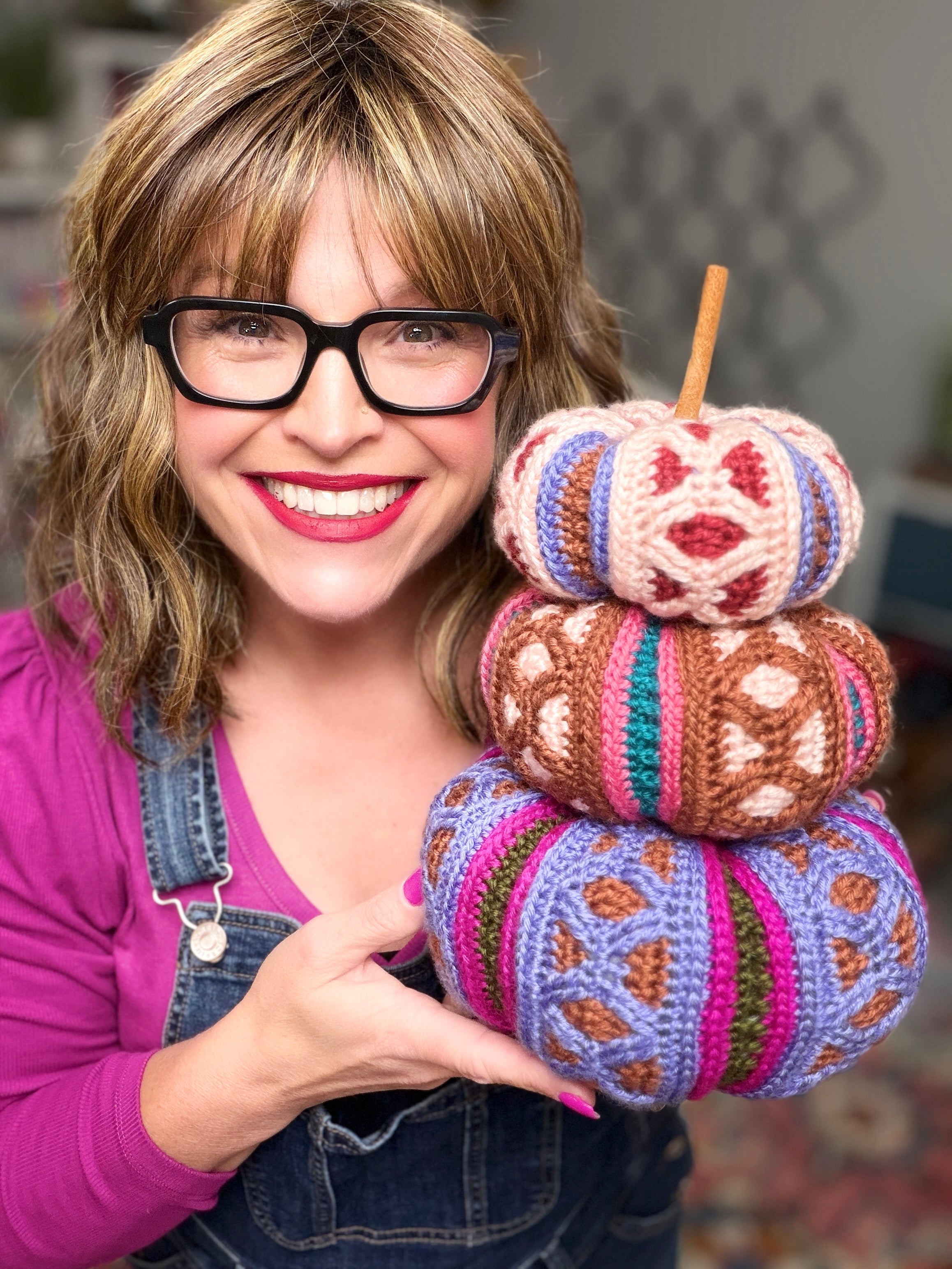 Stacked trio of mosaic crochet pumpkins in pink, brown, and purple colorways