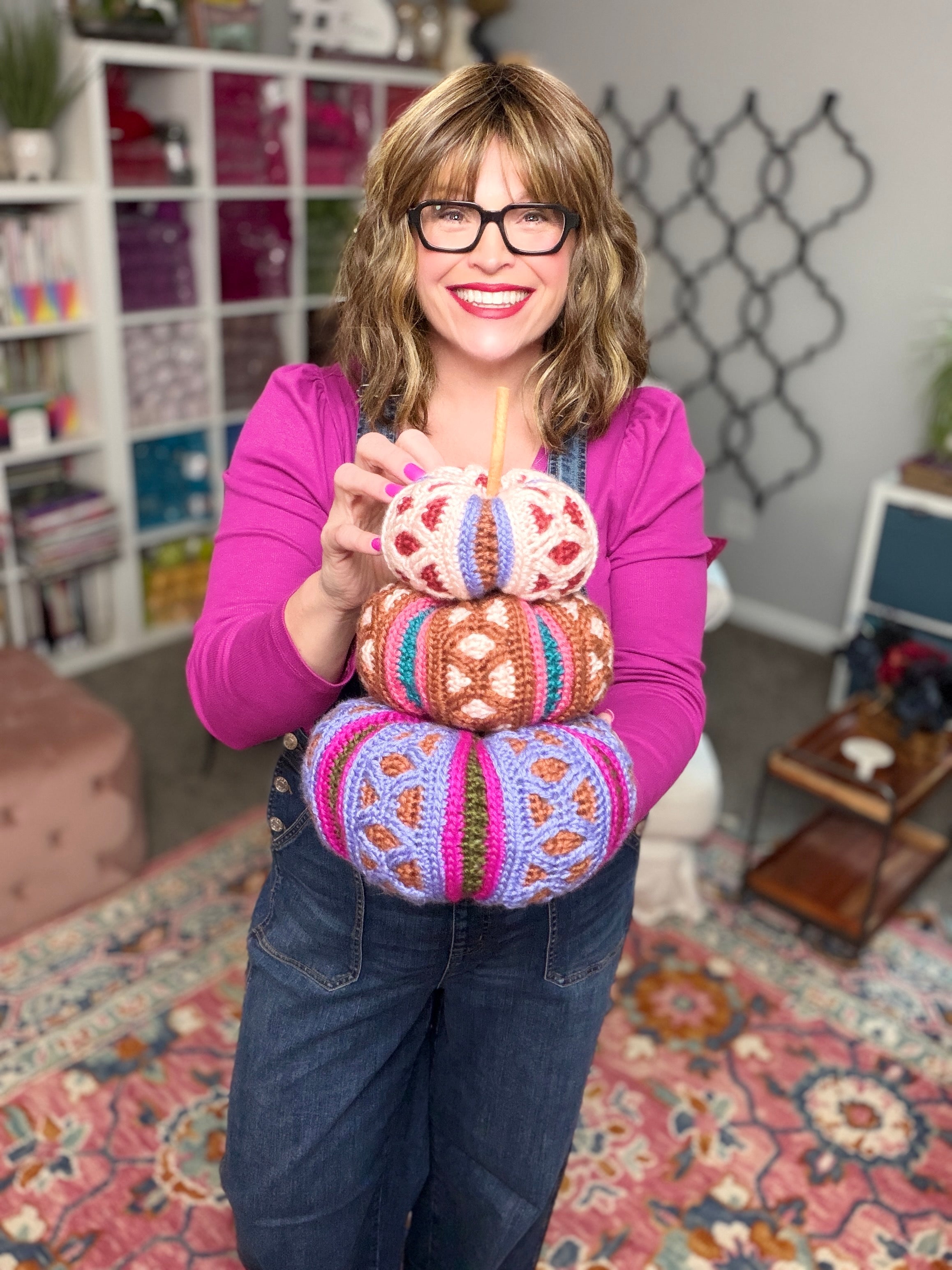 Stacked trio of mosaic crochet pumpkins in pink, brown, and purple colorways