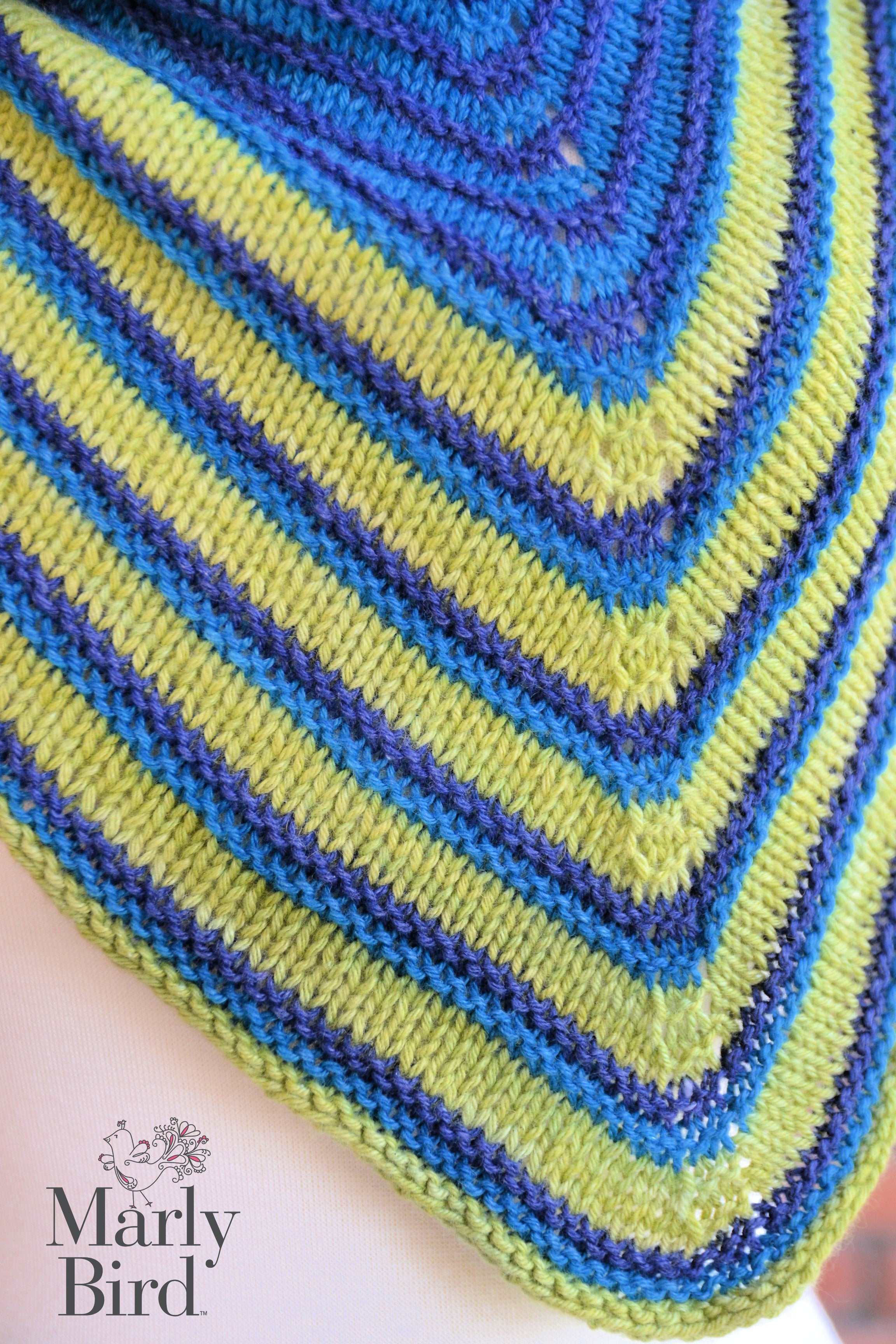 Close-up of a knitted fabric with blue and green pattern, featuring the brand 'Marly Bird'. Make It Mine Knit Shawl triangle shawl pattern garter stitch striped knit wrap