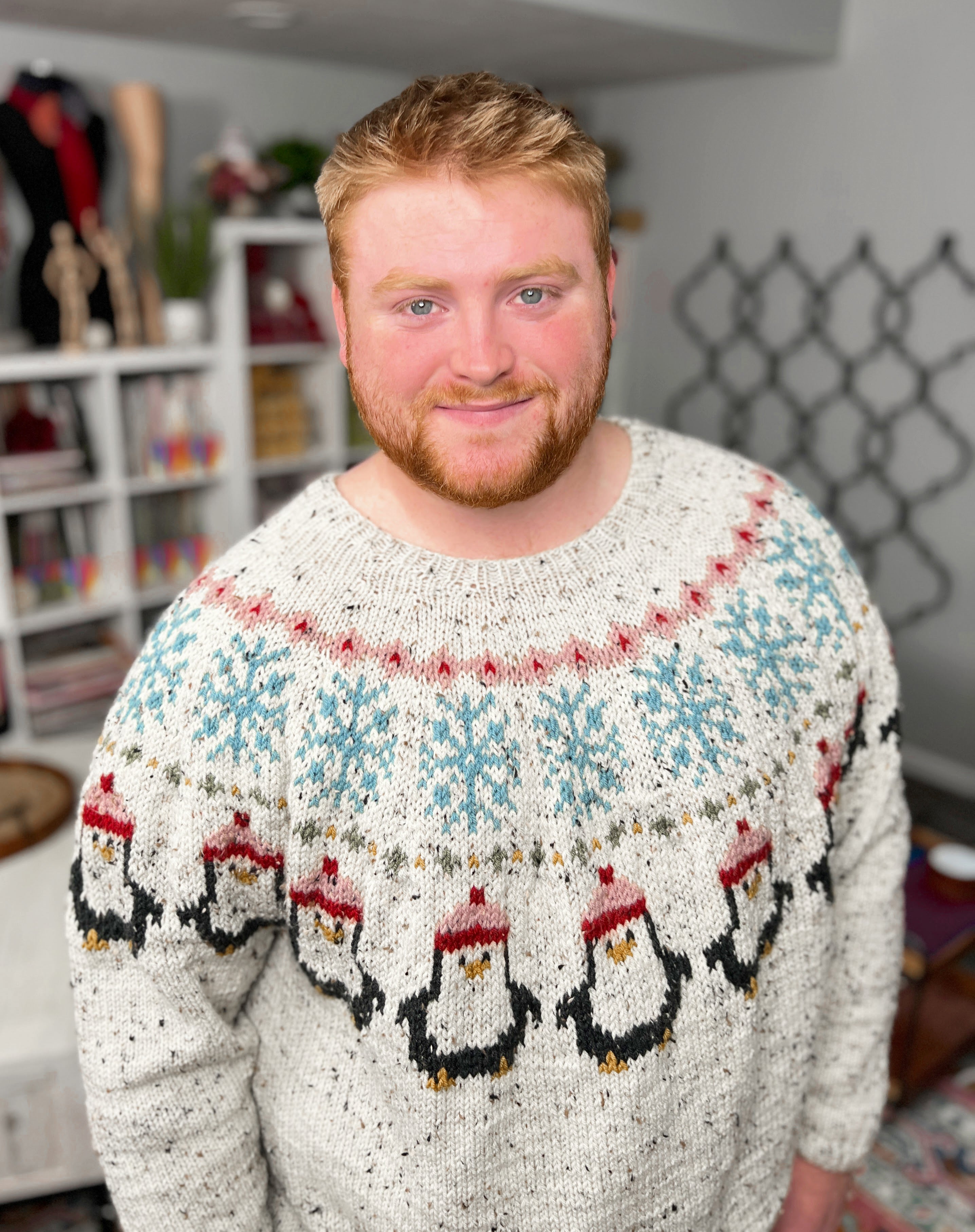 Man wearing a sweater with penguin design in a room setting