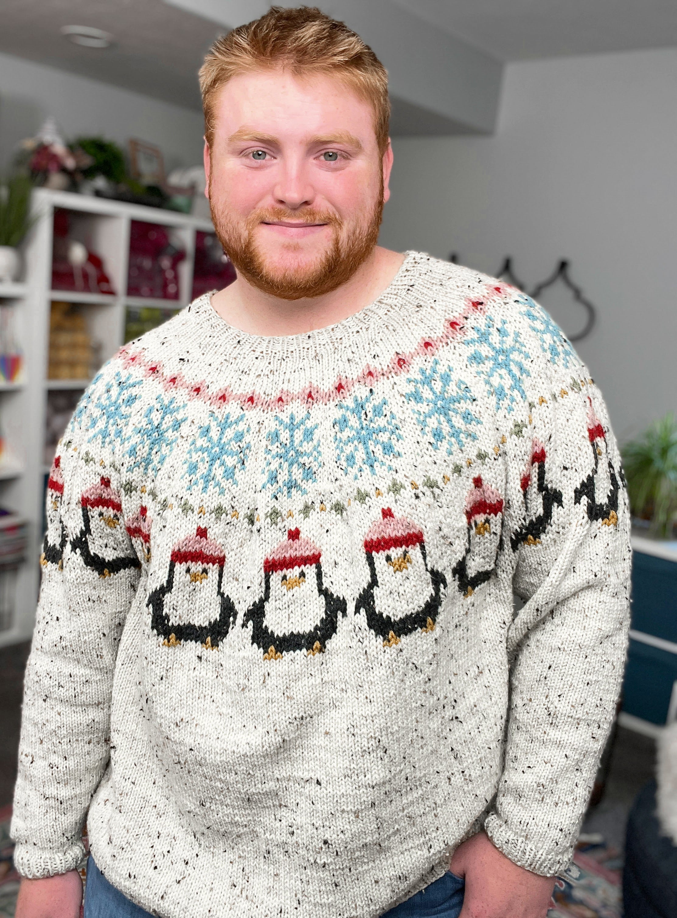 Man wearing a sweater with penguin design in a room setting