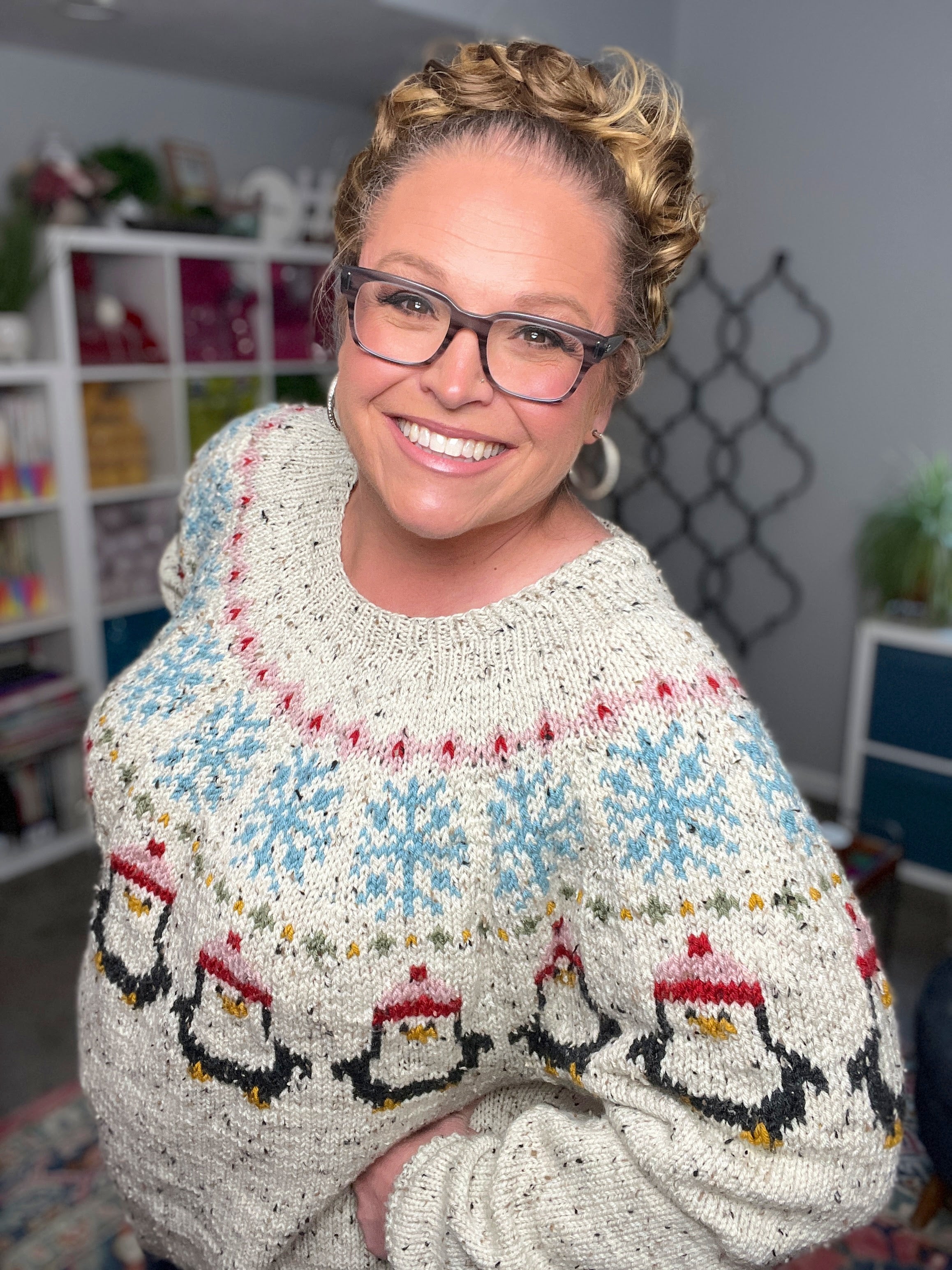 Woman wearing a patterned sweater with penguins in an indoor setting