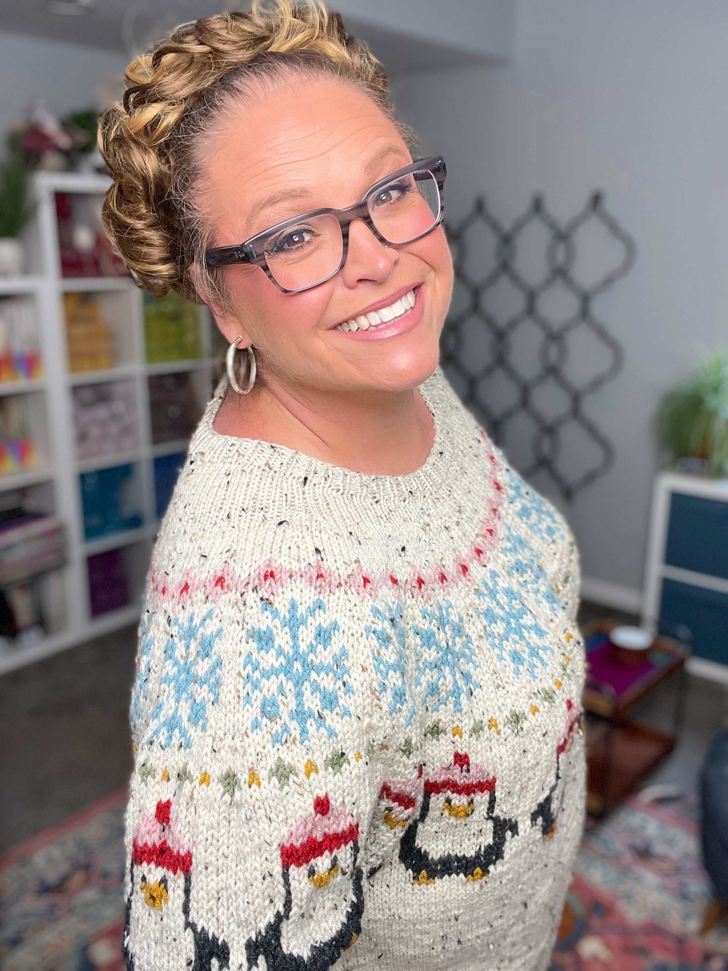 Woman wearing a colorful sweater with a pattern in a room.
