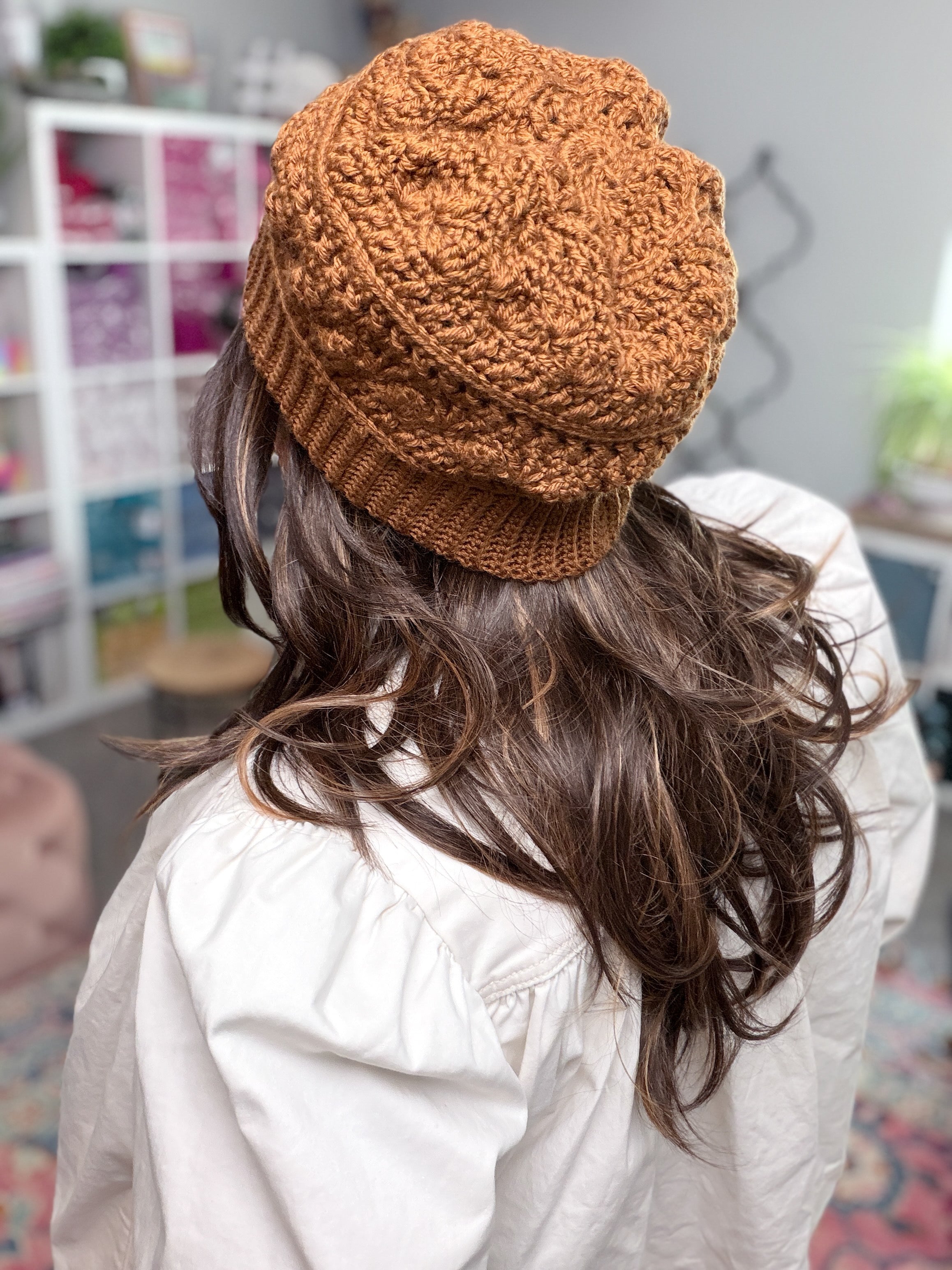 Marly Bird wearing the Toasted Marshmallow Crochet Hat, a caramel shell stitch beanie with single crochet through the back loop ribbed brim