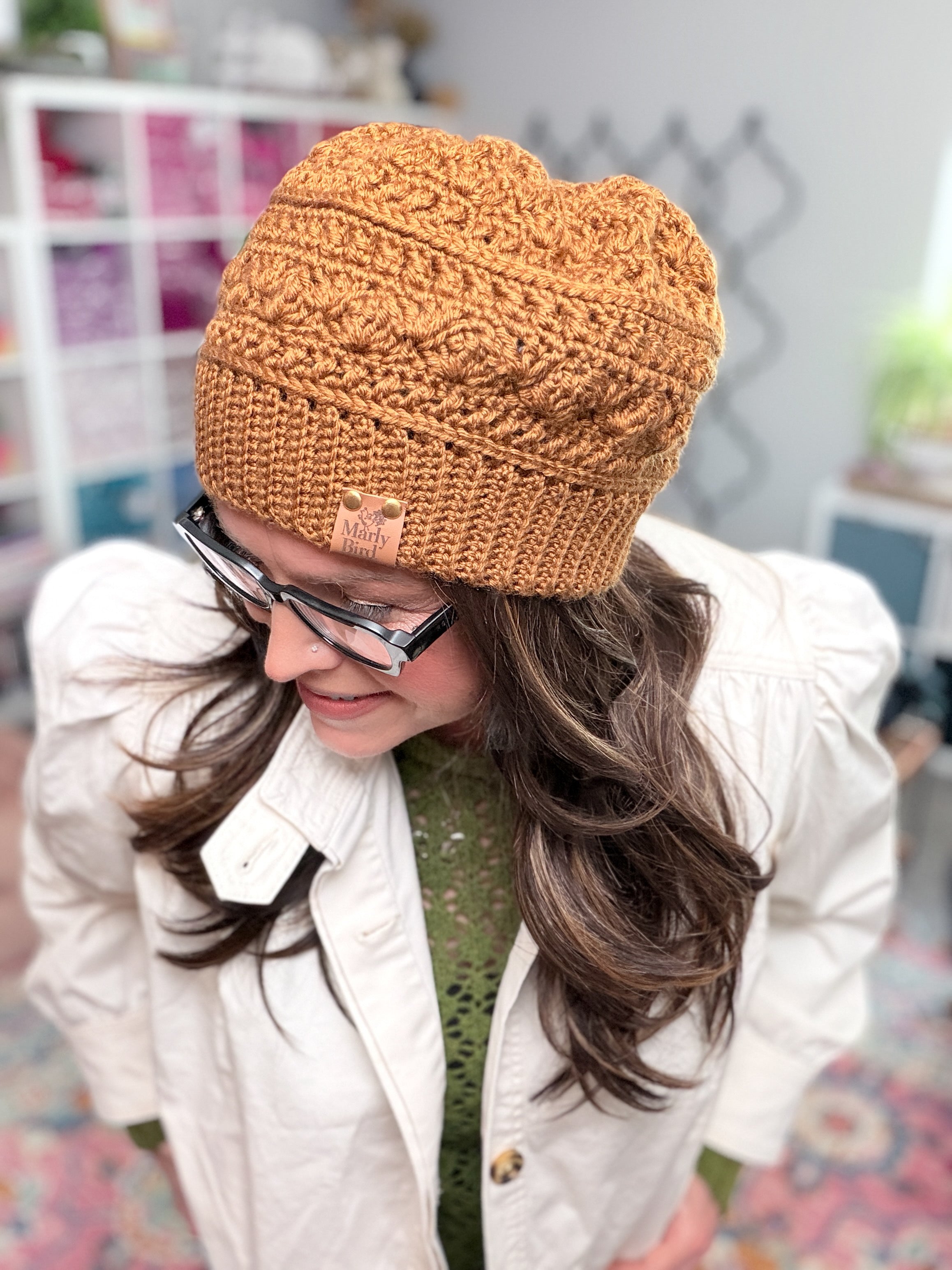 Marly Bird wearing the Toasted Marshmallow Crochet Hat, a caramel shell stitch beanie with single crochet through the back loop ribbed brim
